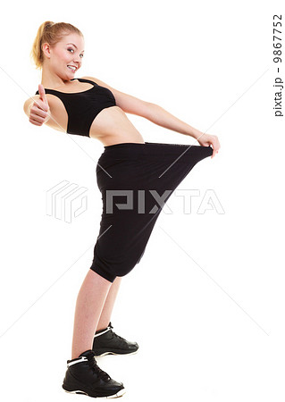happy woman showing how much weight she lost, big pants 9867752