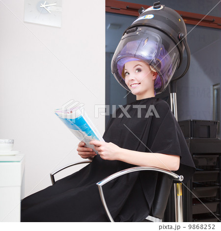 Woman client curlers in hair reads magazine hairdressing beauty salon. Woman client curlers in hair reads magazine hairdressing beauty salon. 9868252