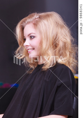 Beautiful smiling girl with blond wavy hair in hairdressing beauty salon Beautiful smiling girl with blond wavy hair in hairdressing beauty salon 9868341
