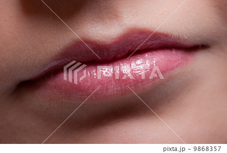 Closeup shiny female lips. Part of face. Makeup and beauty. 9868357