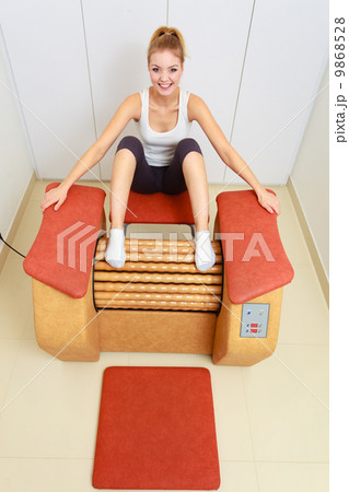 Girl in sportwear on relax massage equipment healthy spa salon 9868528