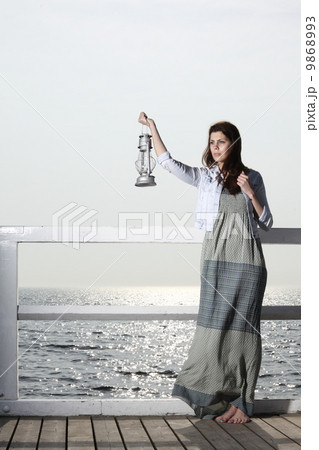 Girl on pier with kerosene lamp Girl on pier with kerosene lamp 9868993