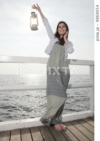 Girl on pier with kerosene lamp Girl on pier with kerosene lamp 9869054