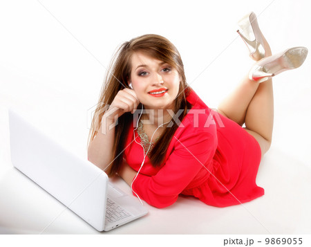 Cute girl with headphones and laptop lying Cute girl with headphones and laptop lying 9869055