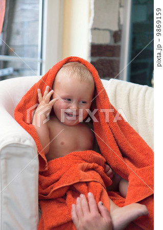 Adorable happy baby boy in orange towel 9869159