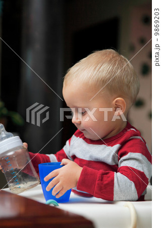 baby boy playing with bottle and mug indoor baby boy playing with bottle and mug indoor 9869203
