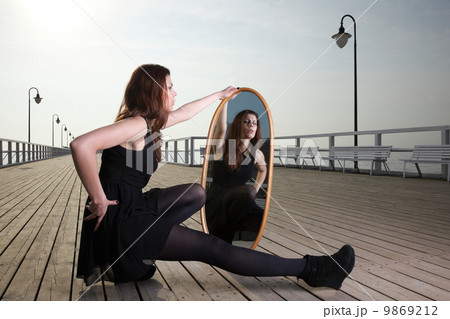 thoughtful woman looks at the reflection in mirror 9869212