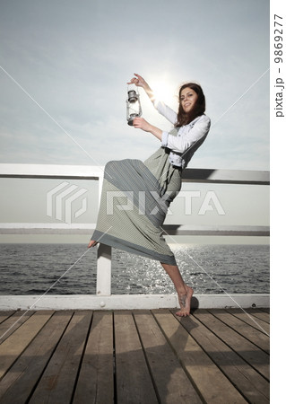 Girl on pier with kerosene lamp Girl on pier with kerosene lamp 9869277