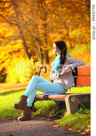Young girl relaxing in autumnal park. Fall lifestyle concept. Young girl relaxing in autumnal park. Fall lifestyle concept. 9869748