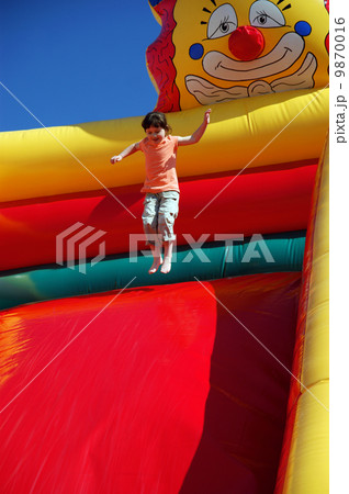 Girl jumping on the colored inflatable slide 9870016