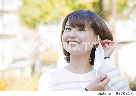 マスクを外す女性 9870817