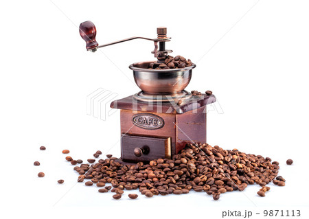 Retro manual coffee mill on roasted coffee beans isolated 9871113