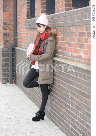 壁にもたれる女性 9871825