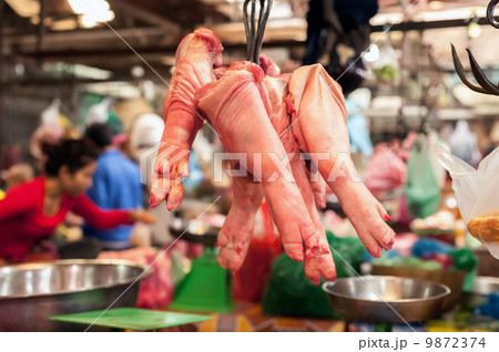 Raw pork legs for sale hanging at asian food market. Cambodia Raw pork legs for sale hanging at asian food market. Cambodia 9872374
