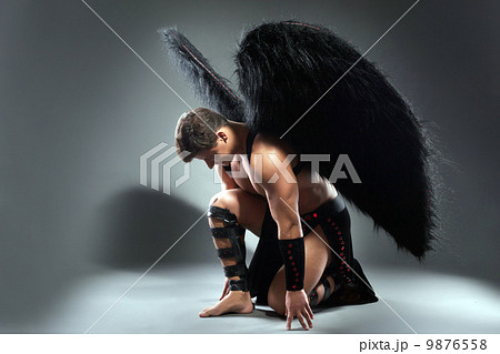 Studio shot of handsome man posing as fallen angel 9876558
