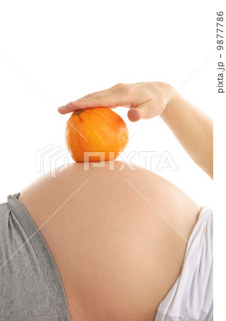 Pregnant woman's abdomen with orange 9877786