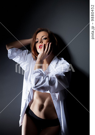 Sexy red-haired woman posing in white blouse 9880452