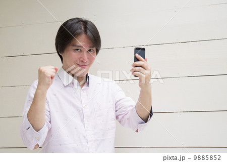ミドル男性　スマホ　ガッツポーズ　カメラ目線 9885852