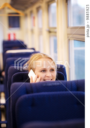 Smiling woman talking on the phone in train. 9885925