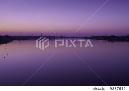 紫色の美しい夕日と水面の反射 9887652