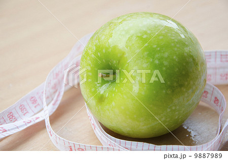 Green apple core and measuring tape. Diet concept Green apple core and measuring tape. Diet concept 9887989