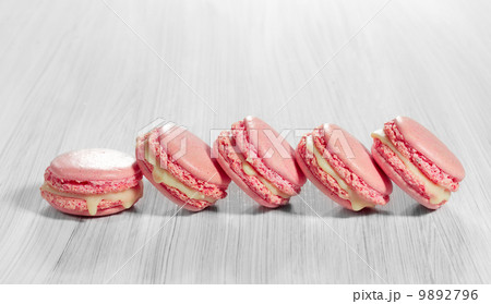 Pink French macarons on a wooden background. 9892796