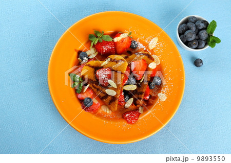 Two pancakes hearts with strawberry, blueberries, almond slivers 9893550