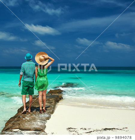 Couple in green on a beach at Maldives 9894078