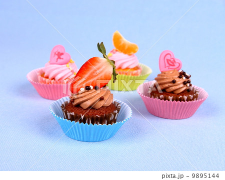 Four appetizing cupcakes with angel, heart, tangerine, strawberry 9895144