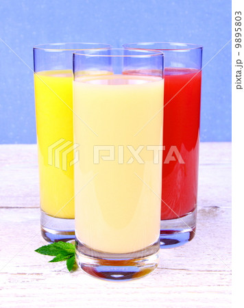 Oranges, bananas and grapefruit juice in glass 9895803