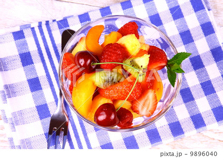 Fruit salad in glass bowl and dessert fork Fruit salad in glass bowl and dessert fork 9896040
