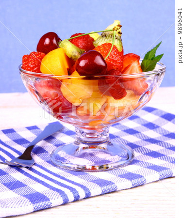 Fruits salad in glass bowl and dessert fork Fruits salad in glass bowl and dessert fork 9896041