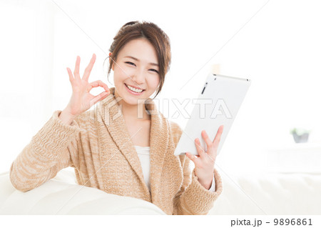 部屋でタブレットを見る女性  9896861