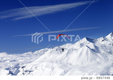 Sky gliding in snowy mountains at nice sun day 9897496