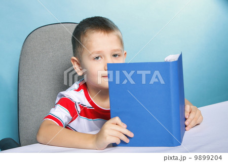 child boy kid reading a book on blue child boy kid reading a book on blue 9899204