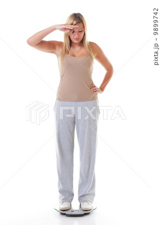 Large woman on scale worried with her weight Large woman on scale worried with her weight 9899742