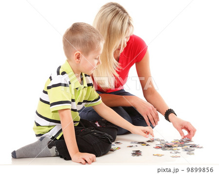 mother playing puzzle together with her son mother playing puzzle together with her son 9899856