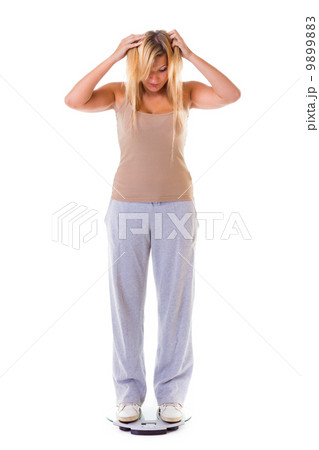 Large woman on scale worried with her weight isolated Large woman on scale worried with her weight isolated 9899883