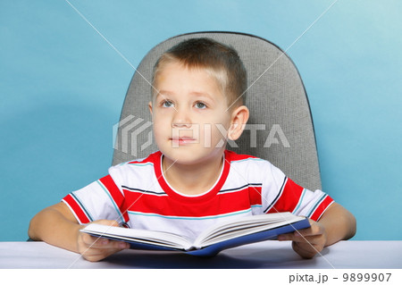 child boy kid reading a book on blue 9899907
