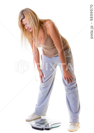 Large woman on scale worried with her weight isolated Large woman on scale worried with her weight isolated 9899970