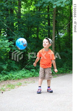 Boy playing with ball in park outdoors Boy playing with ball in park outdoors 9900013