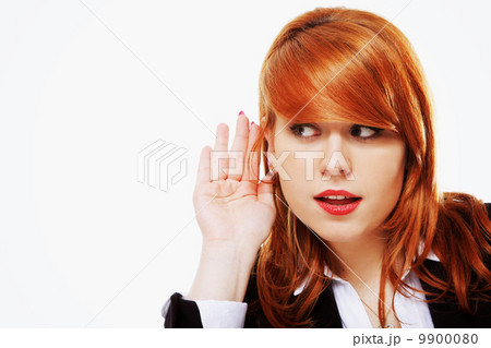 Business woman with hand to ear listening isolated 9900080