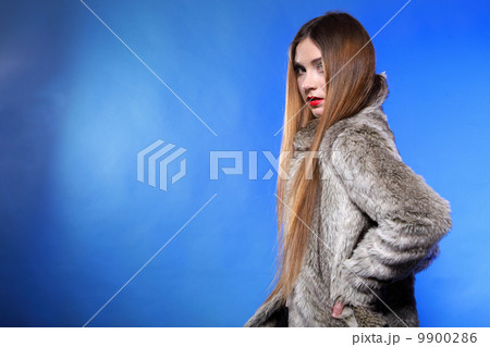 portrait of young woman in fur blue background portrait of young woman in fur blue background 9900286