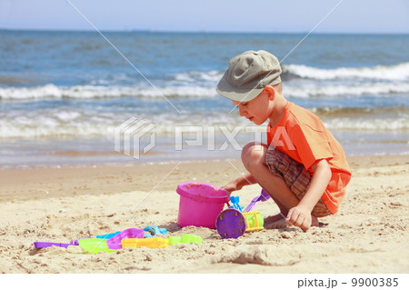 boy playing toys on beach 9900385