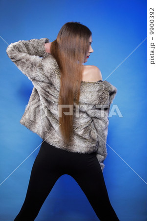 young woman in fur long hair blue background 9900392