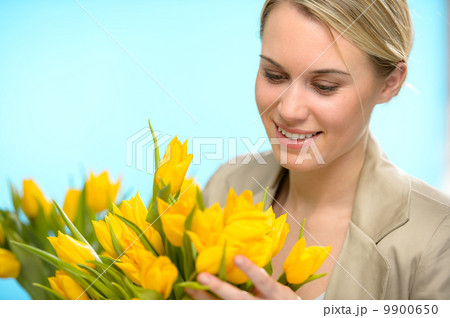 Woman looking down at spring yellow tulips 9900650