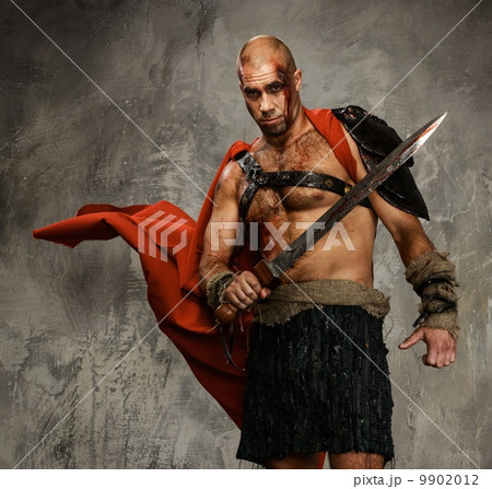 Wounded gladiator with sword covered in blood isolated on grey Wounded gladiator with sword covered in blood isolated on grey 9902012