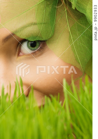 Smiling young woman hiding in a fresh spring grass Smiling young woman hiding in a fresh spring grass 9902933