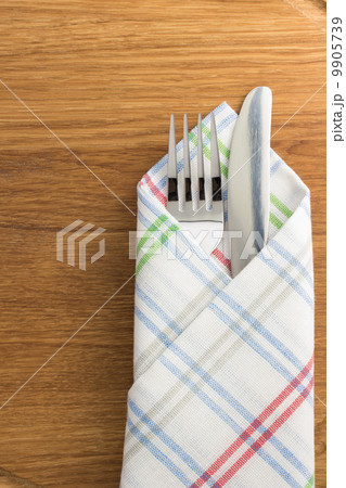 knife and fork at napkin on wood 9905739