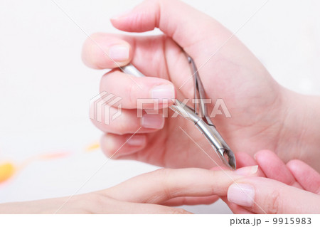 Beautician trimming cuticles of female client in beauty salon 9915983